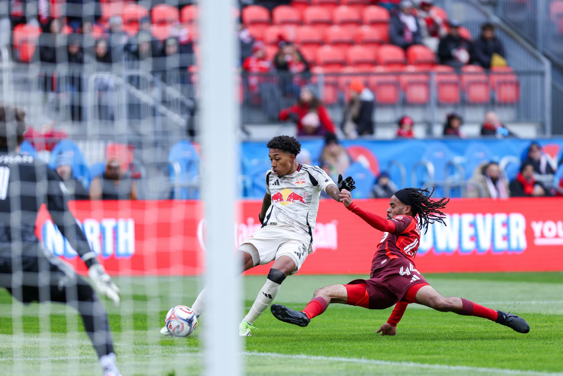 Jahkeele Marshall-Rutty of New York Red Bull attempts to shoot the ball while Toronto FC defender Raheem Edwards