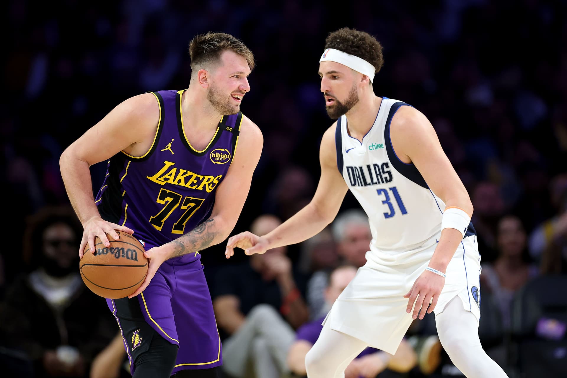 Luka Doncic #77 looks to pass past Klay Thompson #31 / Getty Images