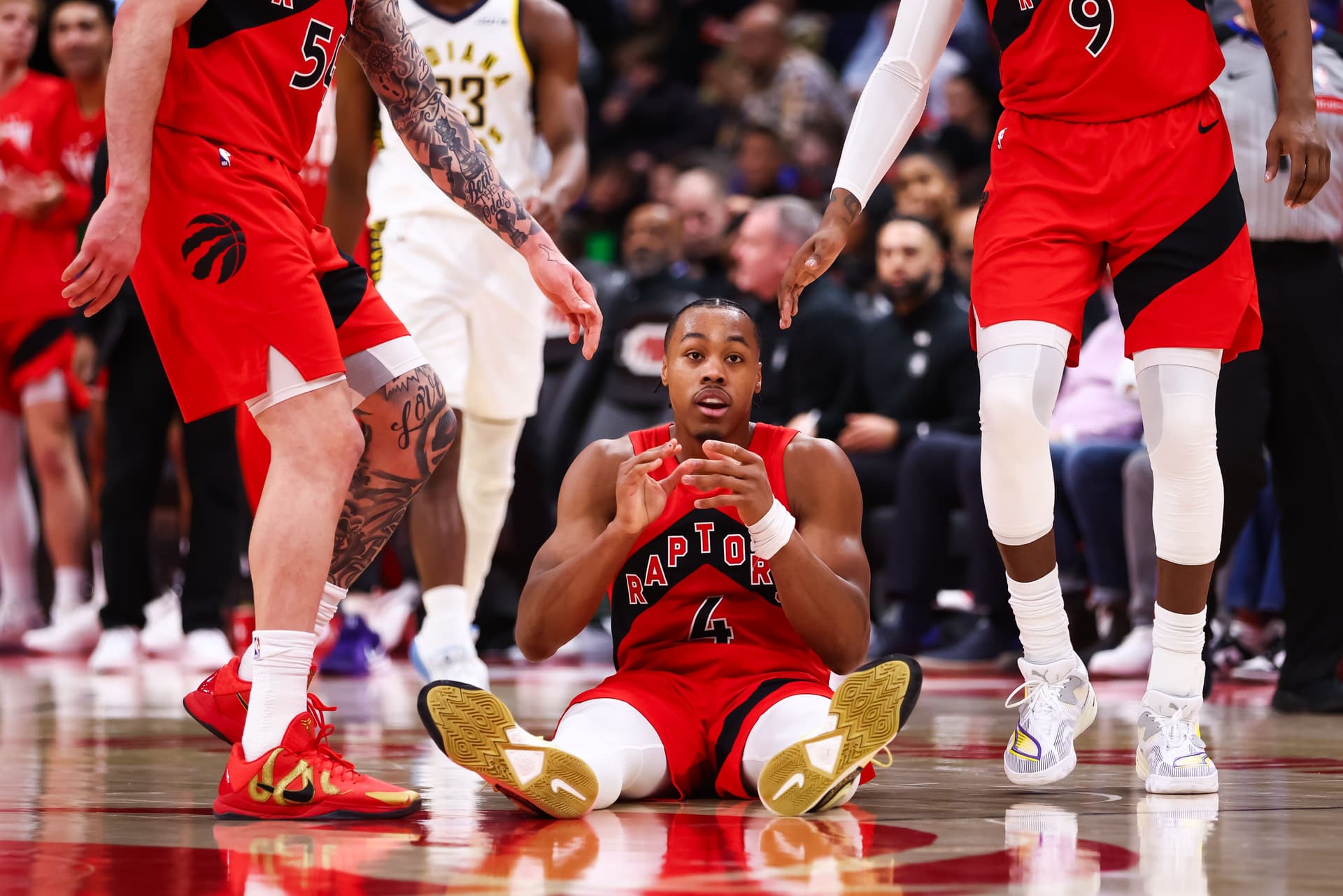 Scottie Barnes #4 of the Toronto Raptors reacts on the floor during the first half of their NBA game